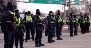 Police line up in preparation to enforce an injunction against a demonstration against COVID-19 restrictions that blocked traffic across the Ambassador Bridge, in Windsor, Ontario, Feb. 12, 2022.