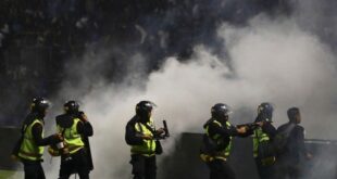 Police officers fire tear gas during a soccer match at Kanjuruhan Stadium in Malang, East Java, Indonesia, Saturday, Oct. 1, 2022.