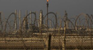 A flame burns off waste gas at Saudi Aramco's Ras Tanura oil refinery and terminal in Ras Tanura, Saudi Arabia. 