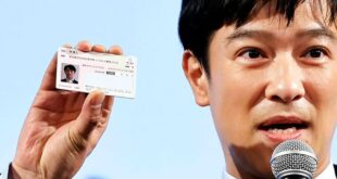 Japanese actor Masato Sakai shows a sample of the My Number card during a promotional event in Tokyo on March 8, 2021.