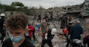 Volunteers work to clean the debris on a site where several houses were destroyed after a Russian attack at a residential area in Zaporizhzhia, Ukraine, Sunday, Oct. 9, 2022. 