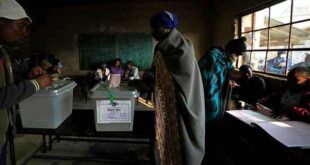 A man wearing a blanket casts his vote at a polling station in Maseru, Lesotho, on Oct. 7, 2022. Voters across Lesotho are heading to the polls Friday to elect a leader to find solutions to high unemployment and crime. 