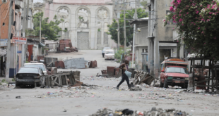 A man walks between road blocks set up by gangs after they waged intense gun battles, shuttering main avenues and a municipal market in the downtown area of the capital, in Port-au-Prince, Haiti July 27, 2022. 