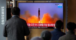 People watch a TV screen showing a news program reporting about North Korea's missile with file footage, at a train station in Seoul, South Korea, Wednesday, March 16, 2022.